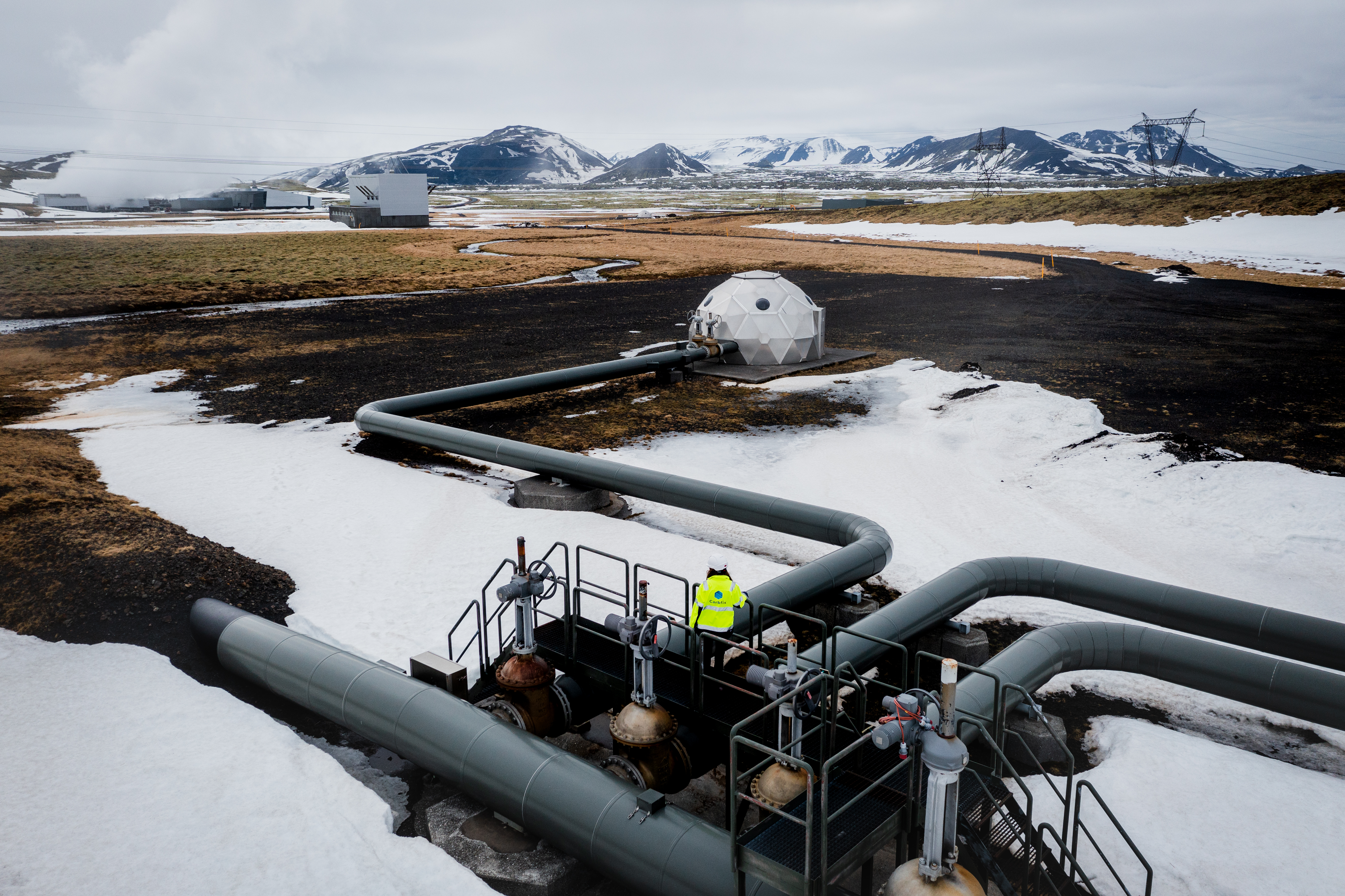 Pipes are running through a rugged snowy Icelandic landscape