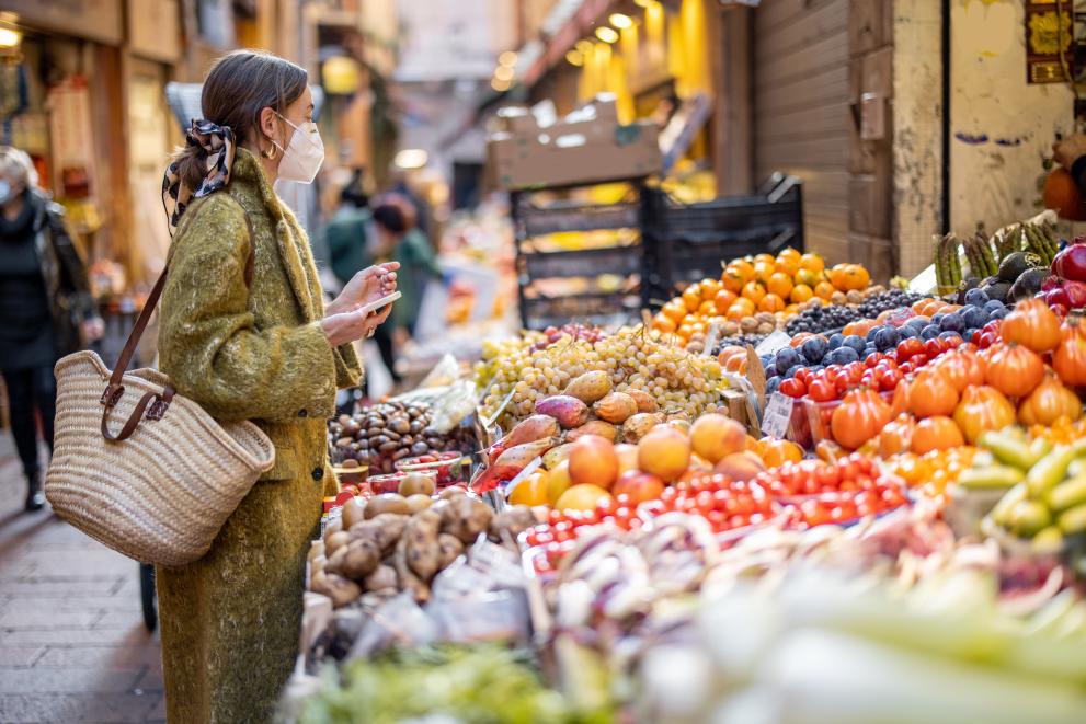 woman picking fruit from a street-market